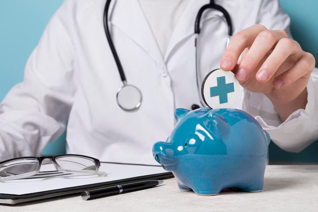 Doctor placing a coin with a medical cross symbol into a blue piggy bank, representing the concept of saving money for a health plan and managing medical expenses effectively.
